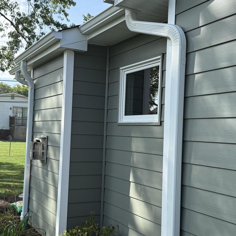 Composite insulated siding with white downspouts and soffit