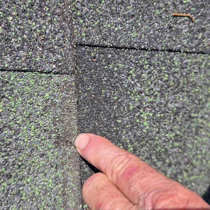 Asphalt roof shingles showing hail damage close-up