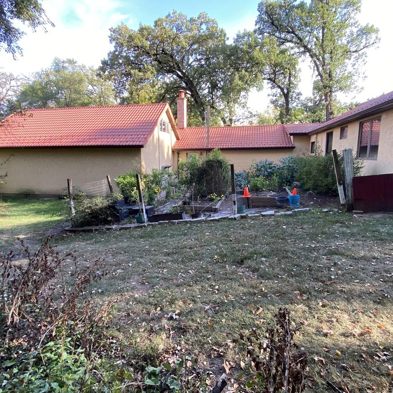 Gutter installation with guards on beige house