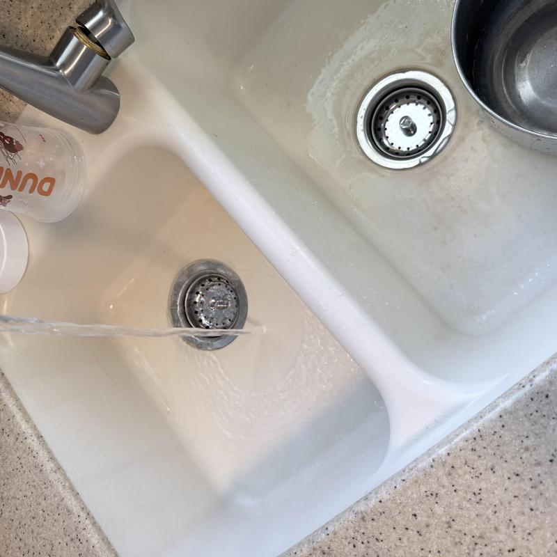 Kitchen sink drain clearing with running water stream Kitchen sink drain clearing with running water stream