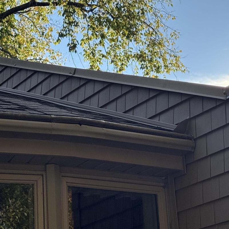 Vinyl shake siding with asphalt roof edge in Deerfield