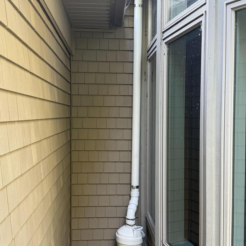 Vinyl shake siding with exterior vent pipe near window