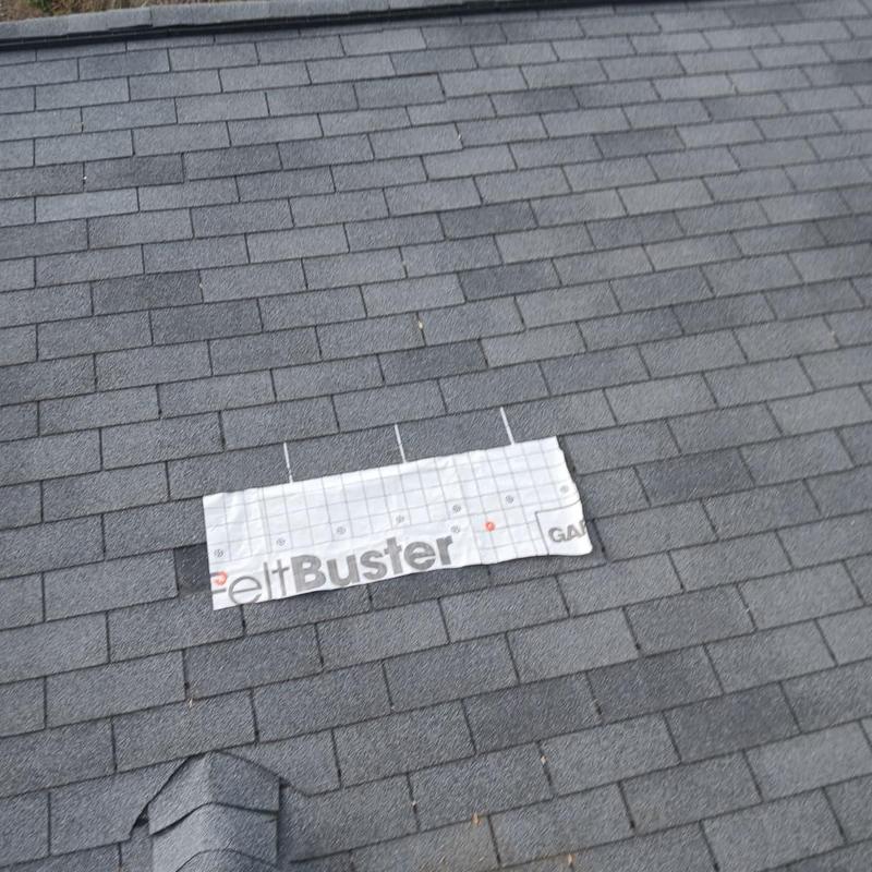 Roof shingles with damaged section covered by underlayment patch