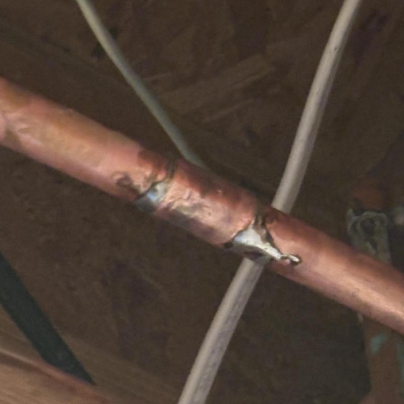 Copper water pipe leak at elbow joint under ceiling