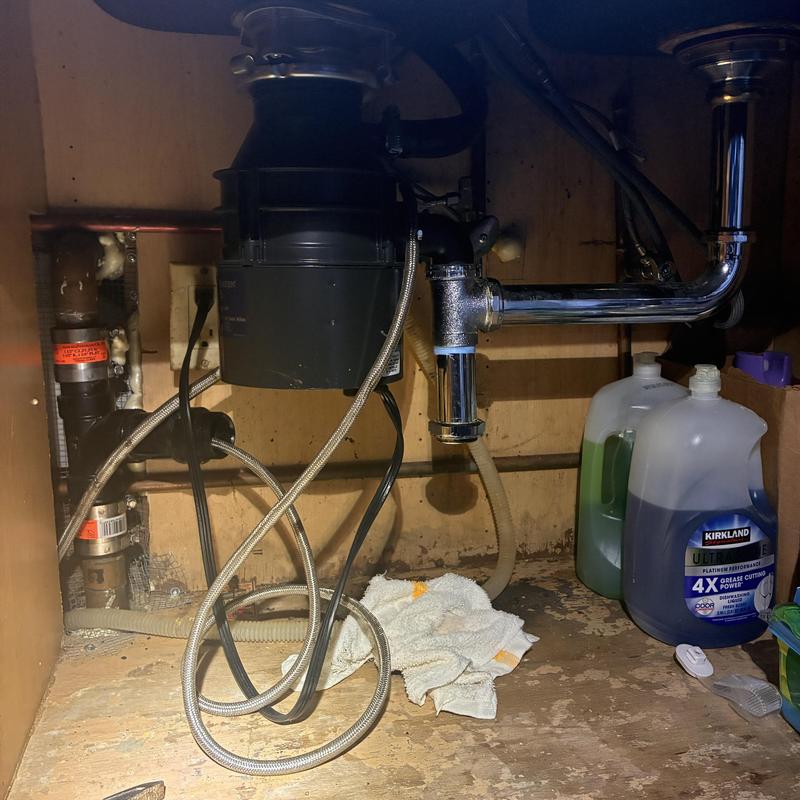 Garbage disposal and kitchen drain pipes under sink