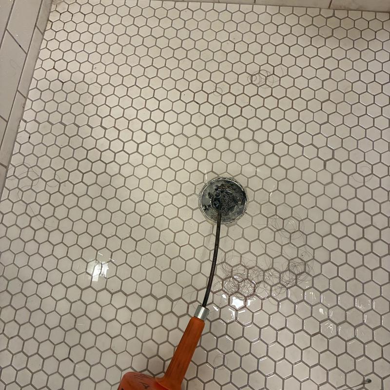 Shower drain clog removal with plumbing snake tool