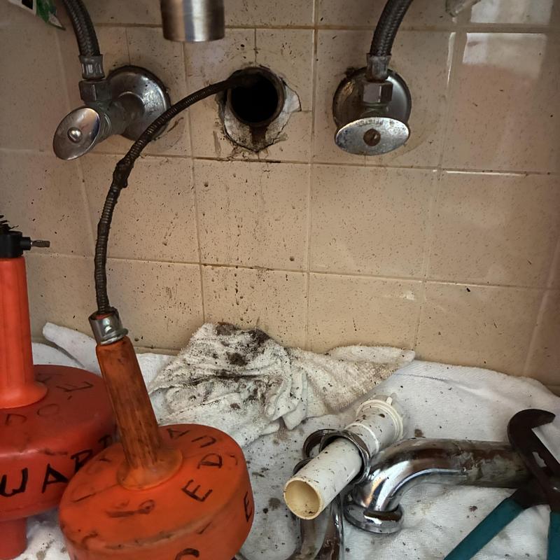 Basin sink drain with removed P-trap and plumbing tools