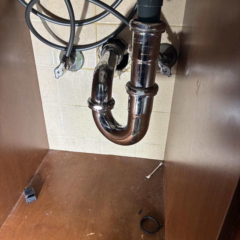 Basin sink chrome P-trap plumbing under cabinet