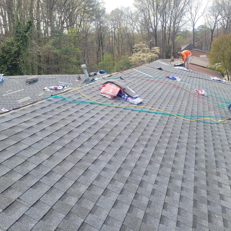 Asphalt shingle roof replacement with worker on roof Asphalt shingle roof replacement with worker on roof