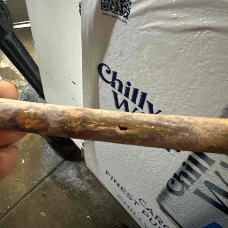 Corroded copper pipe with visible hole and damage Corroded copper pipe with visible hole and damage