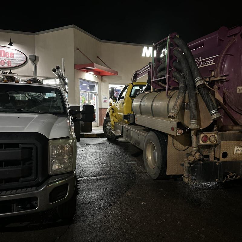 Vac truck with hoses parked at plumbing site at night Vac truck with hoses parked at plumbing site at night