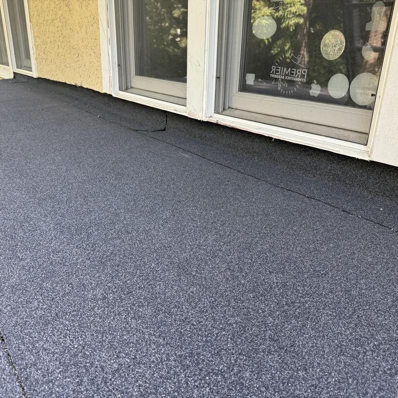 Flat roof surface with sealant near window frame