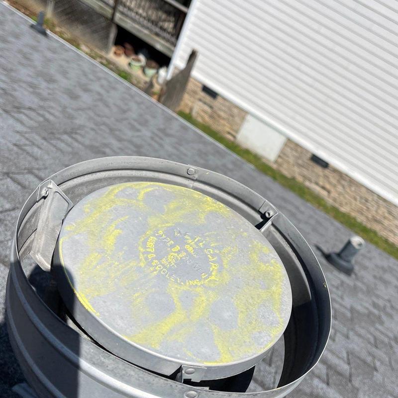 Metal roof vent with hail damage on asphalt shingles