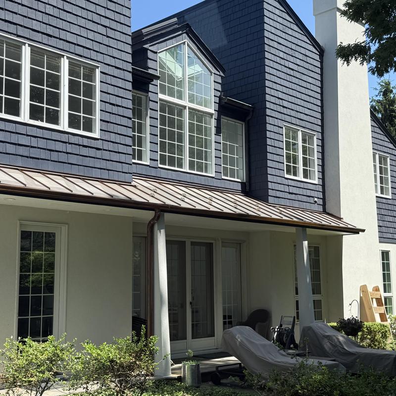 Copper gutters and downspouts on residential house exterior