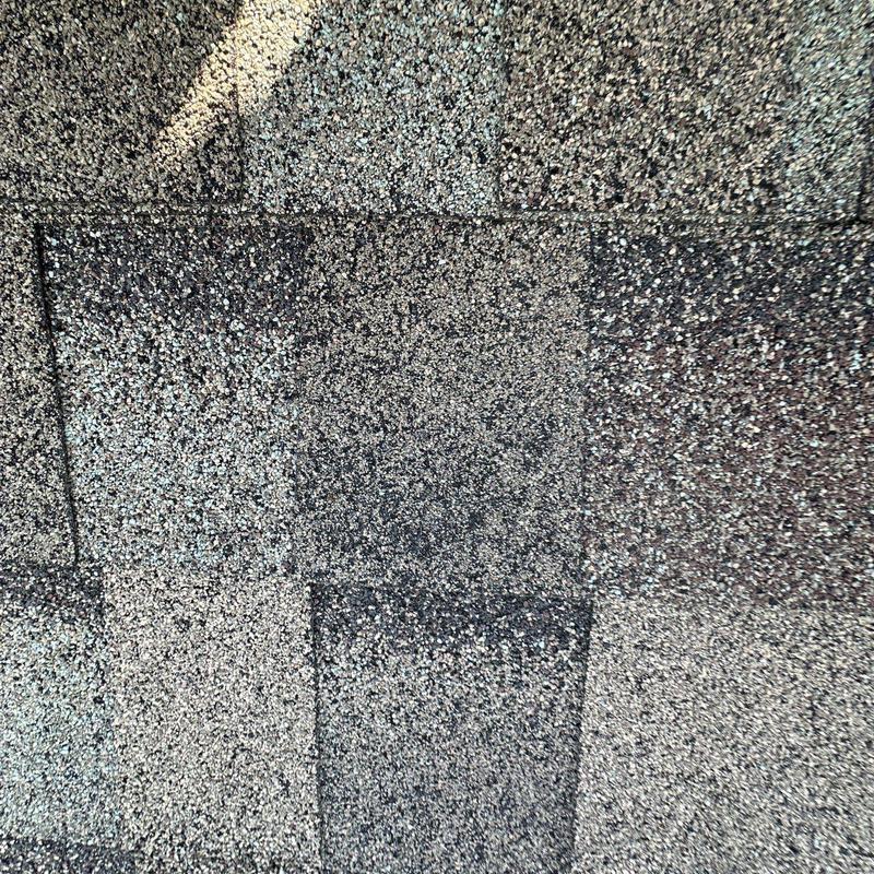 Hail-damaged asphalt roof shingles close-up