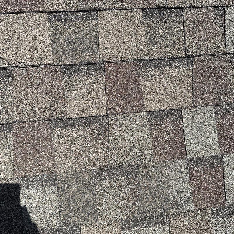 Asphalt shingles with hail damage on roof surface