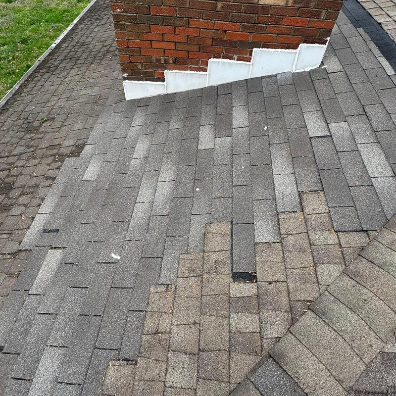 Asphalt shingle roof with chimney flashing inspection