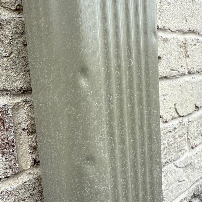 Asphalt shingle hail damage on roof panel near brick wall