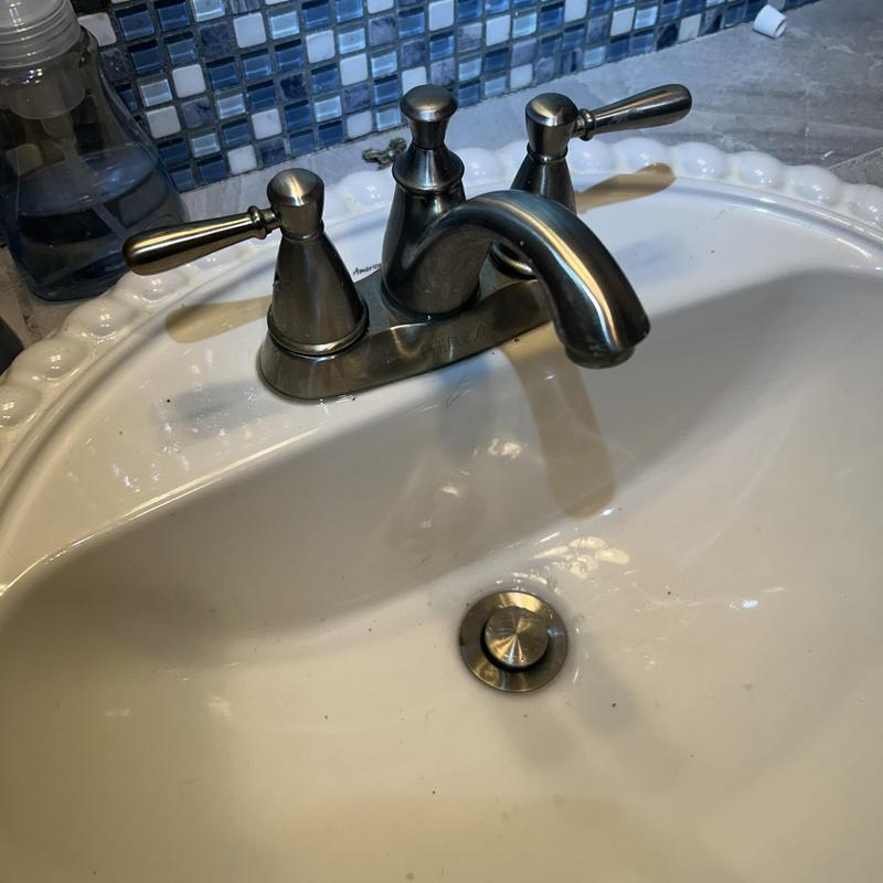 Bathroom faucet with metal handles and sink basin