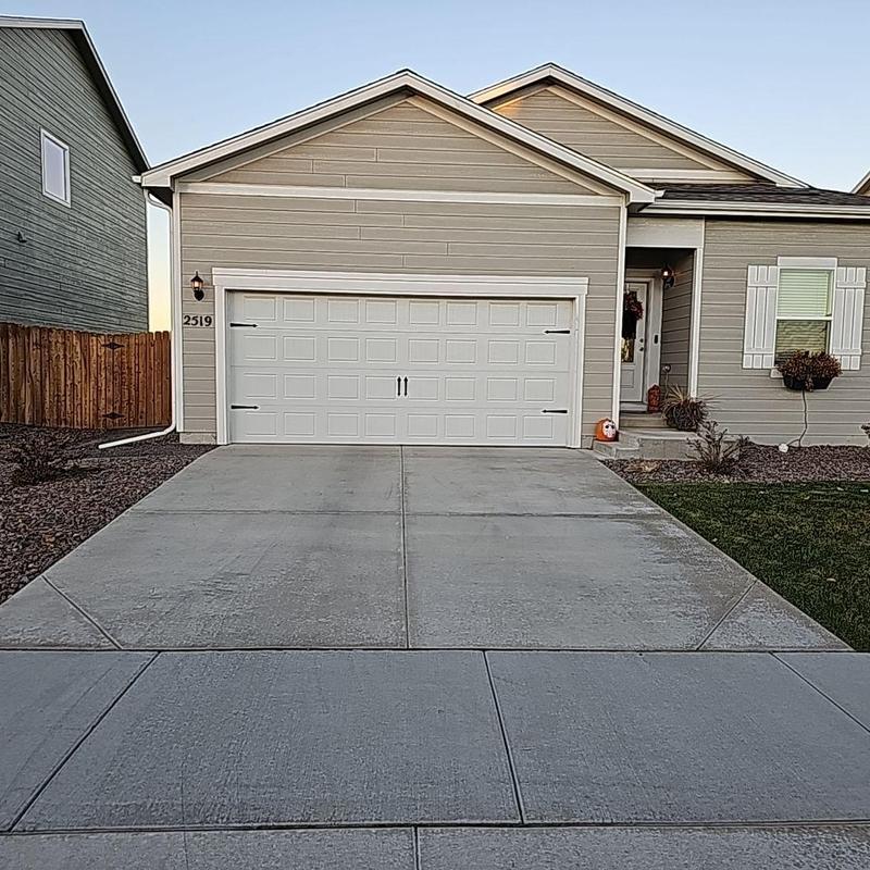 Garage door and driveway of beige suburban house Garage door and driveway of beige suburban house