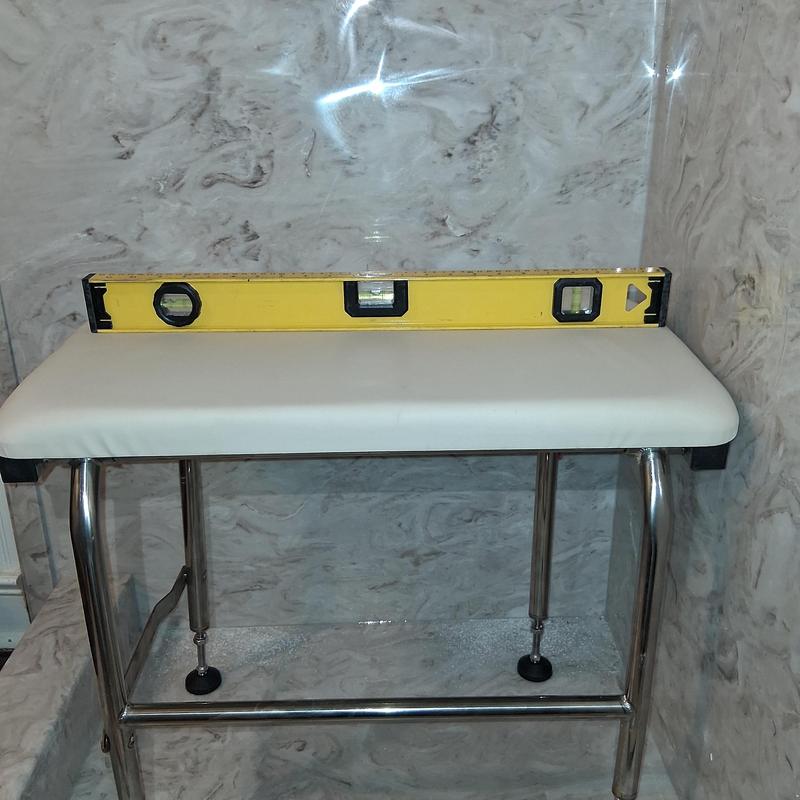 ADA compliant shower seat with level tool in shower
