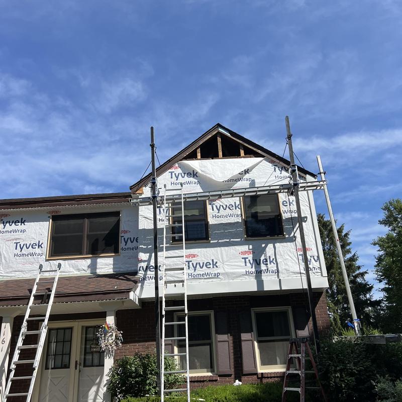 Vinyl siding installation with scaffolding and ladders