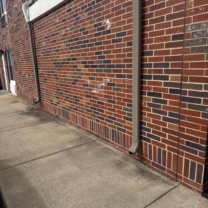 Gutters and downspouts along brick exterior wall