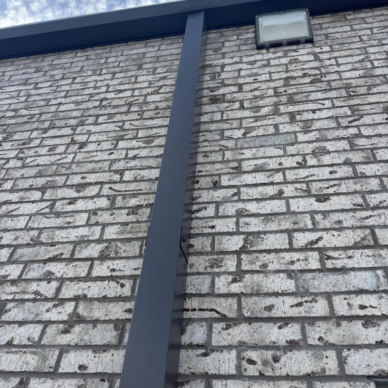 Metal vertical flashing on brick wall exterior
