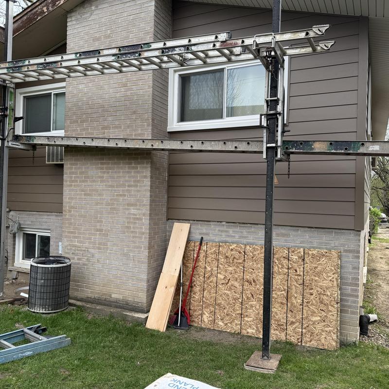 Composite insulated siding installation with scaffolding outdoors