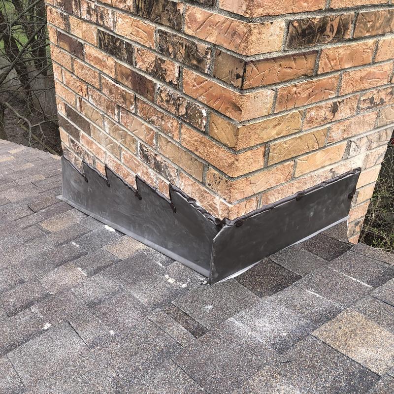 Chimney metal flashing installation on asphalt roof