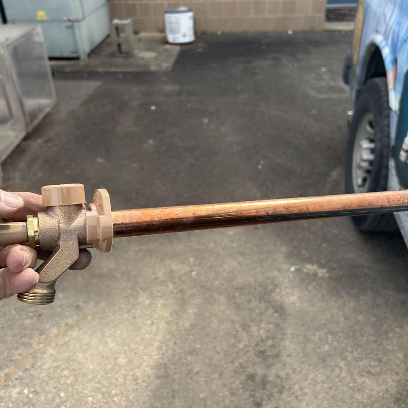 Hose bib with attached copper pipe held outdoors Hose bib with attached copper pipe held outdoors