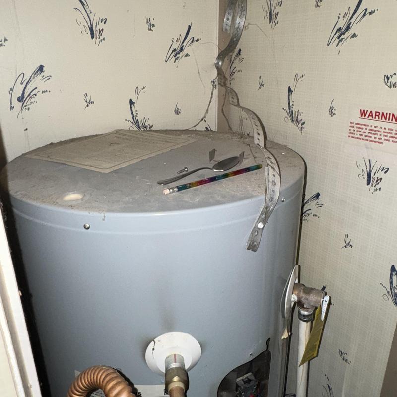 Water heater tank with pencil and spoon on top