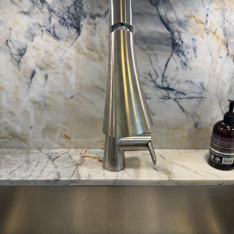 Kitchen faucet with stainless steel finish on marble countertop