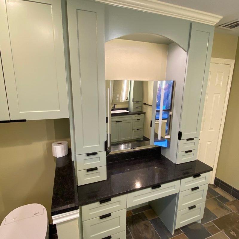 Bathroom vanity with black countertop and light blue cabinetry Bathroom vanity with black countertop and light blue cabinetry