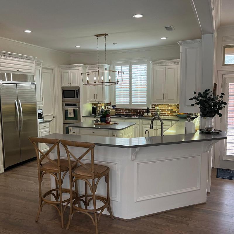 Quartz countertop and brick tile backsplash in kitchen