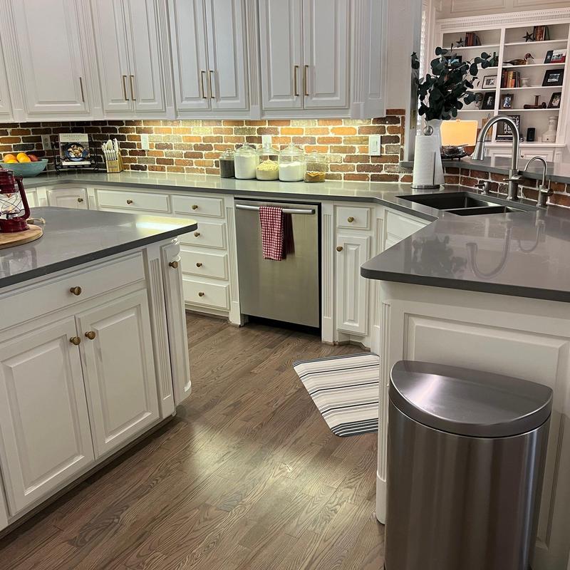 Quartz countertops and brick backsplash in kitchen