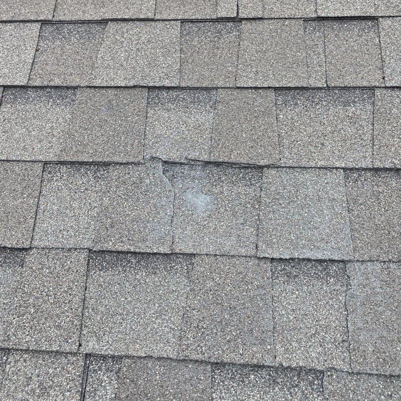 Damaged asphalt shingles with granule loss on roof