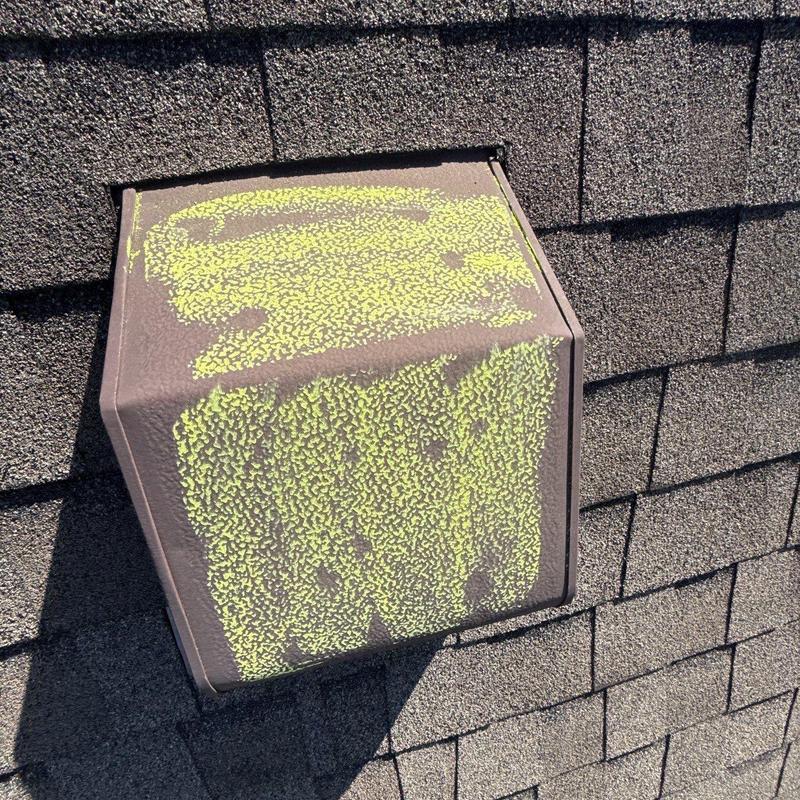 Roof vent with yellow hail impact markings on shingles