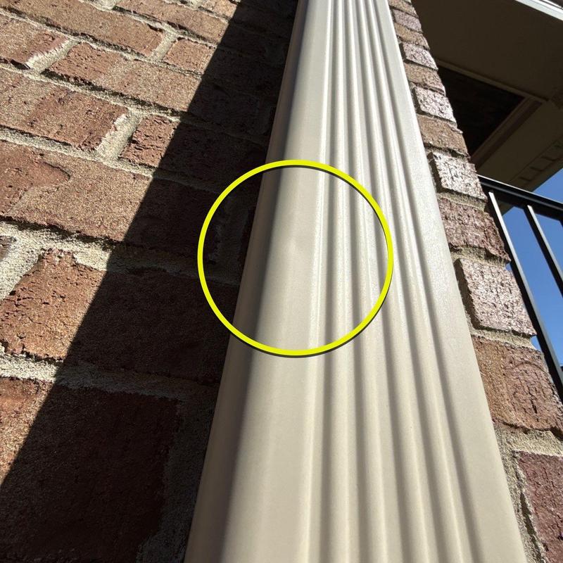 Vinyl siding panel with dent marked by yellow circle