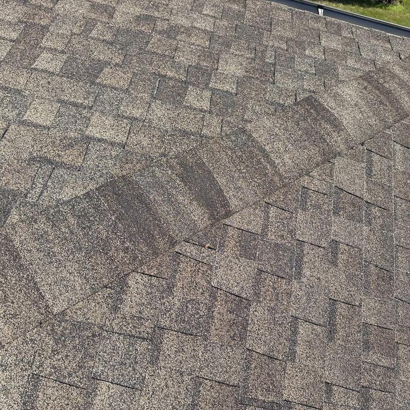 Asphalt shingle roof ridge with hail damage inspection