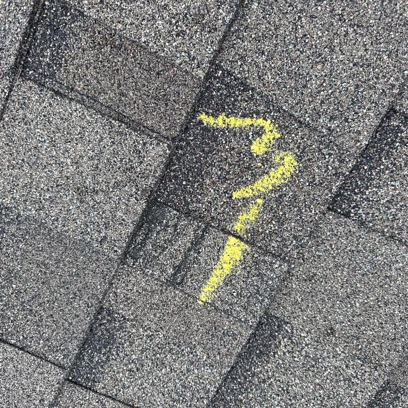 Asphalt roof shingles with yellow chalk hail damage mark