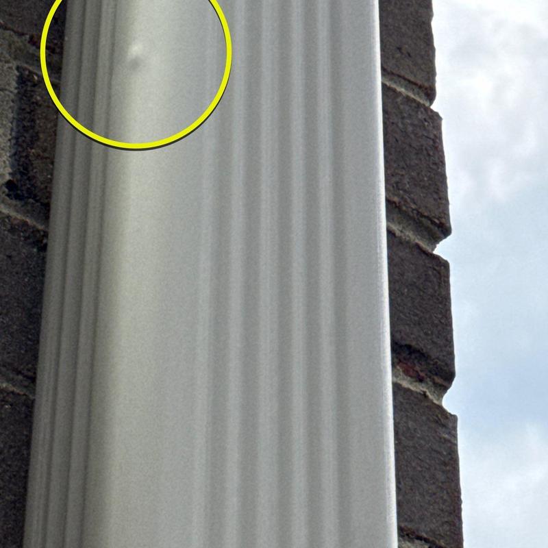 Vinyl siding hail damage with dent close-up view