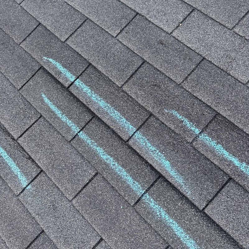 Roof shingles with chalk-marked hail damage