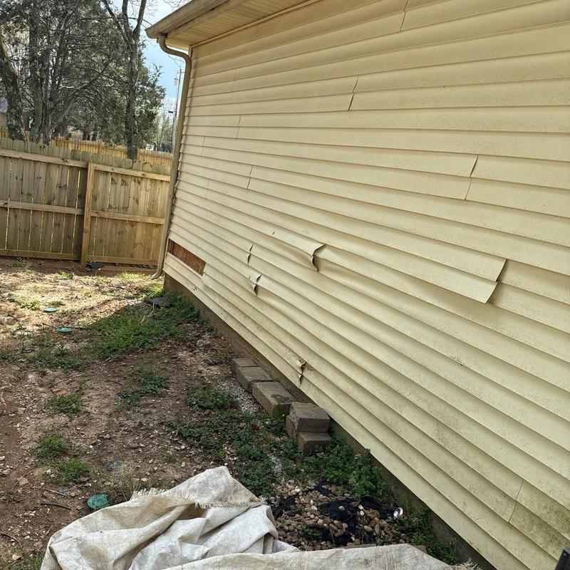 Vinyl siding with warping and damage on exterior wall