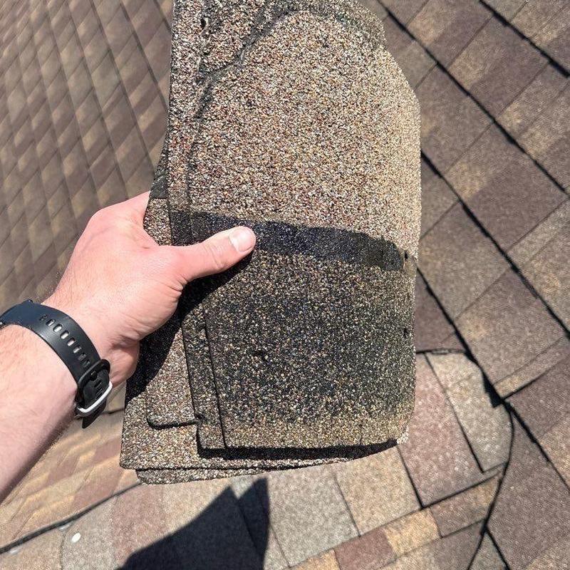 Asphalt shingles with hail damage held on roof