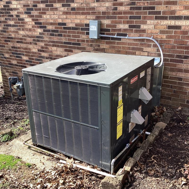 Goodman outdoor HVAC unit beside brick wall Goodman outdoor HVAC unit beside brick wall