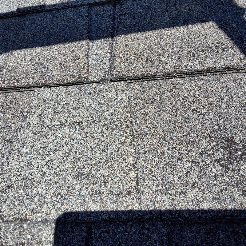 Asphalt shingles with wind damage and granule loss