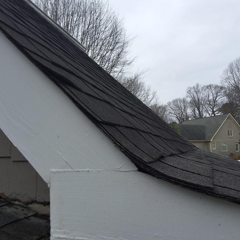 Roof shingles with visible warping and damage