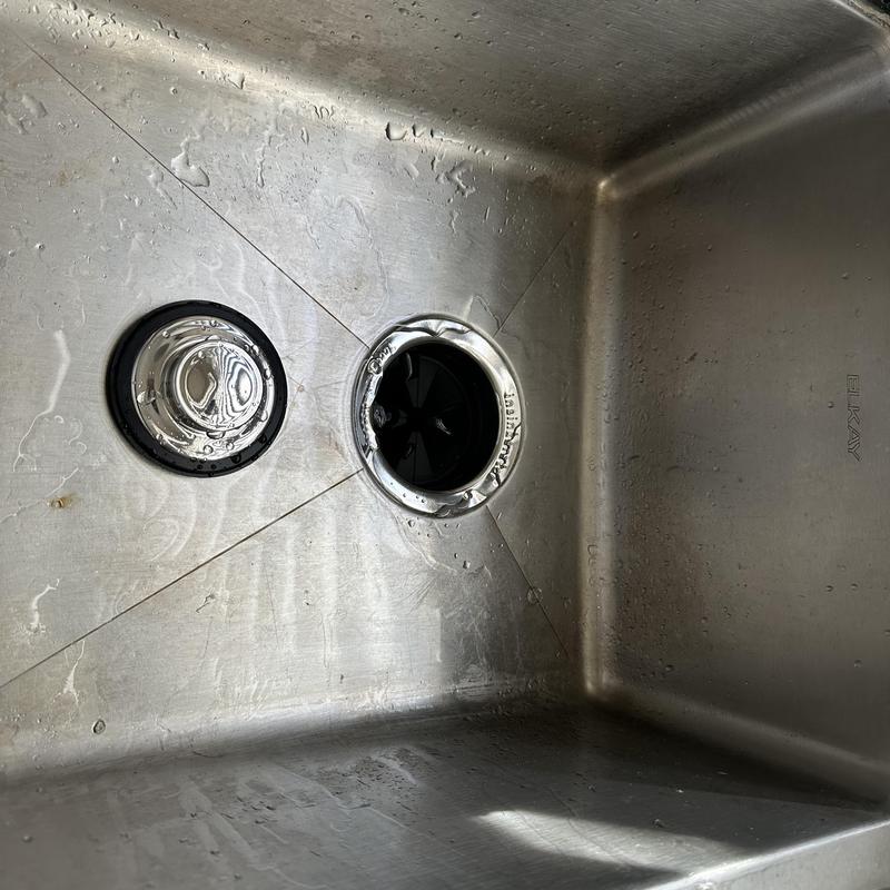 Garbage disposal drain opening in stainless sink basin