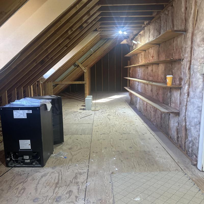 Attic insulation and plywood flooring installation with shelves